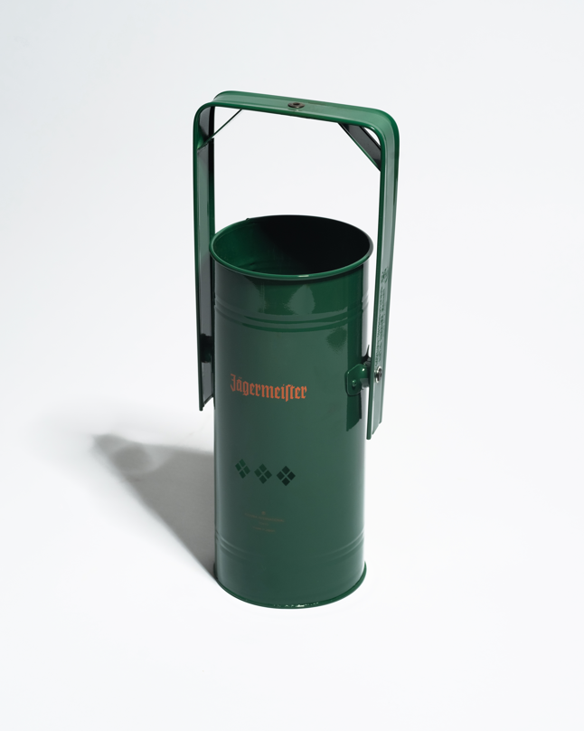 Groene metalen wierookbrander met handvat en oranje Jägermeister-logo op een witte achtergrond
