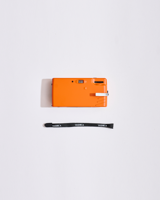 Oranje camera met een draagriem op een witte achtergrond
