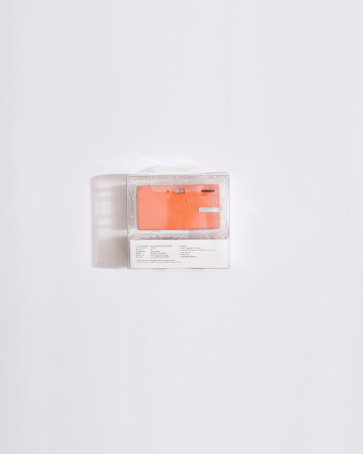 oranje camera in een doorzichtige plastic verpakking op een witte achtergrond