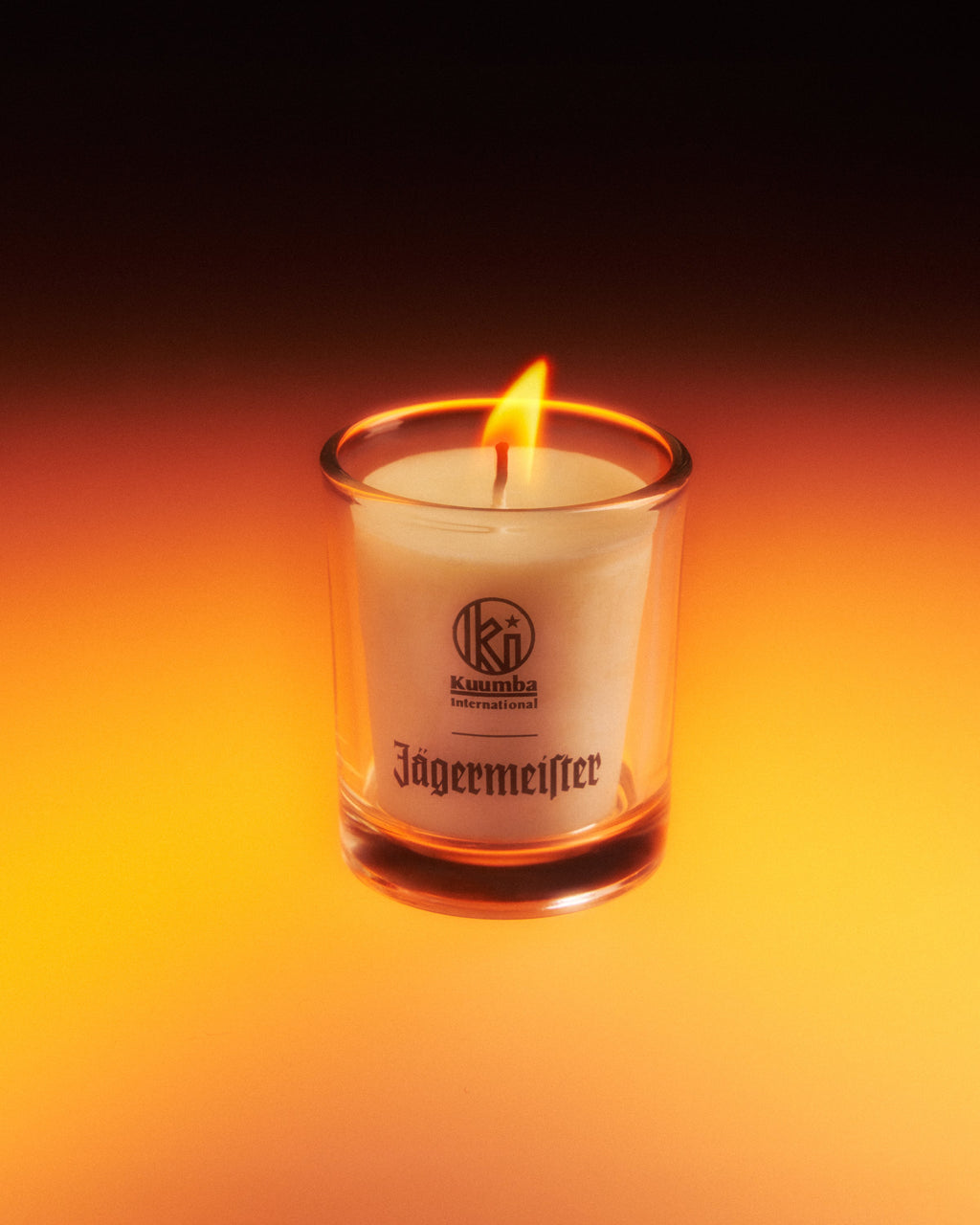 Jagermeister-kaars in een glazen houder met een donkere achtergrond