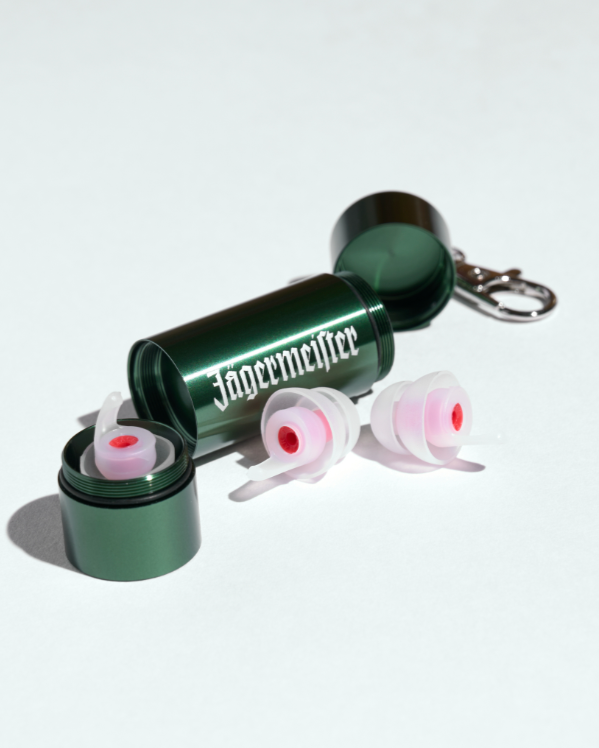 Oordoppen in een groene metalen koker met daarop een witte Jägermeister-woordmarkering op een witte achtergrond