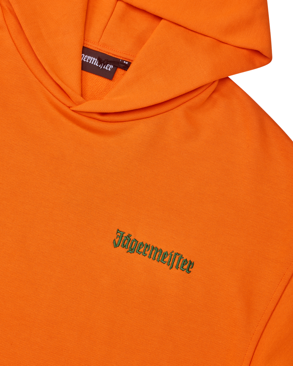 Oranje hoodie met groene Jägermeister-woordmarkering op de borst.