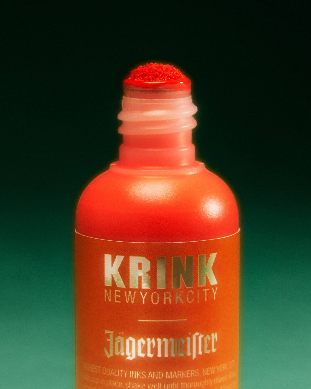 Oranje Krink-marker met Jägermeister-branding op een groene achtergrond