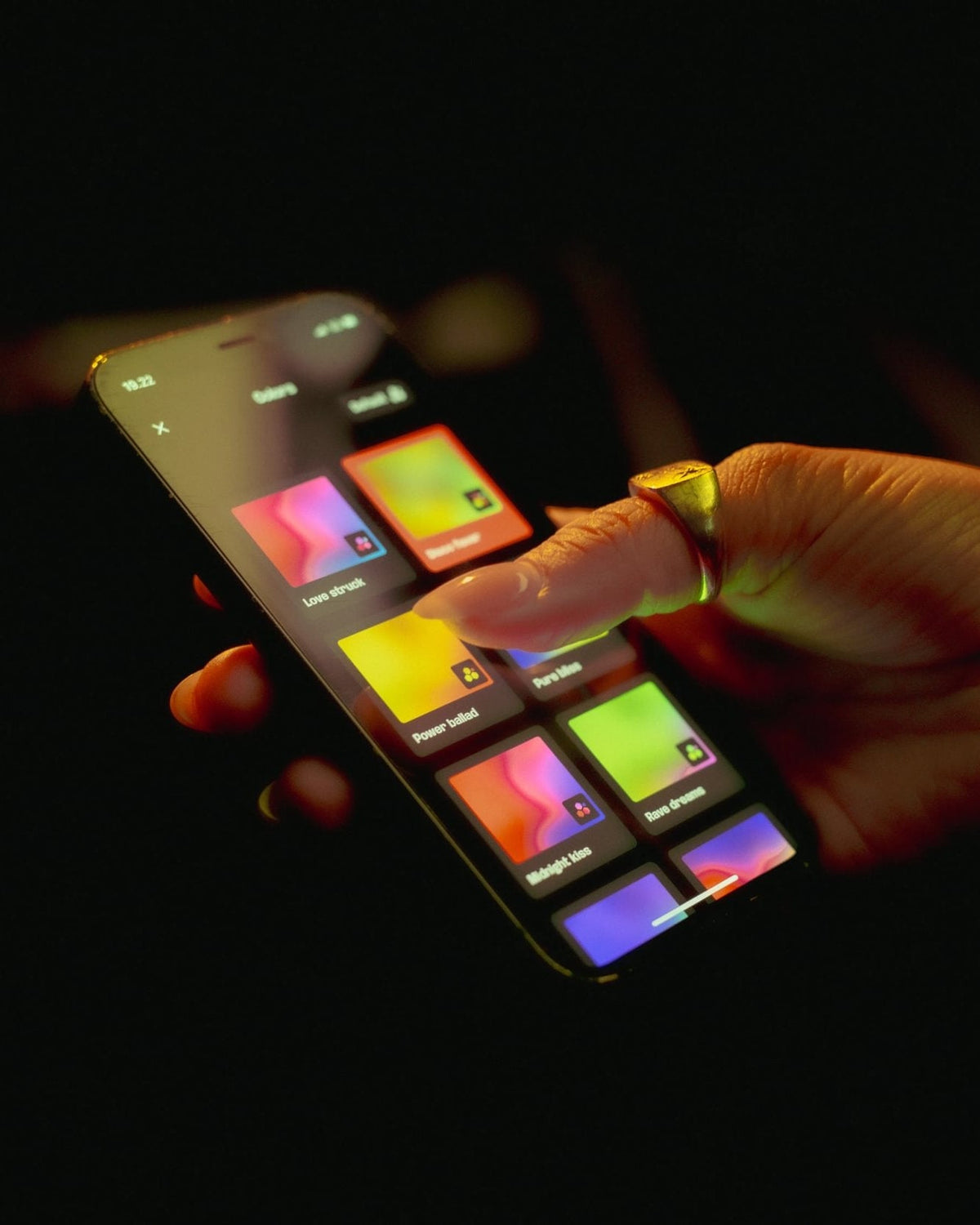 Hand die interactie heeft met een kleurrijk digitaal apparaat op een donkere achtergrond