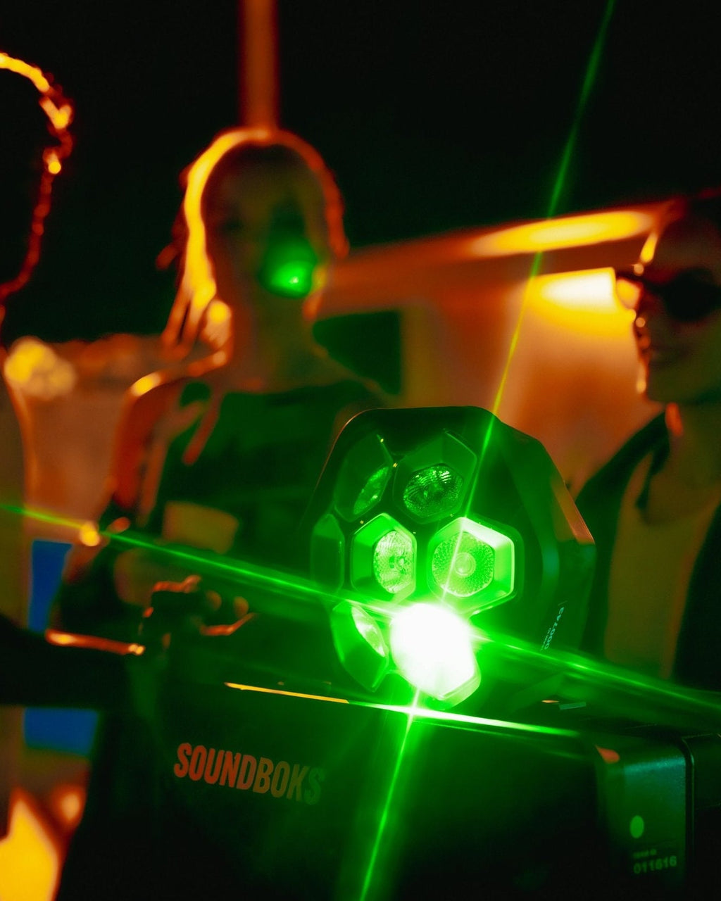 Groene oplichtende LIghtboks op een Soundboks, omringd door feestende mensen