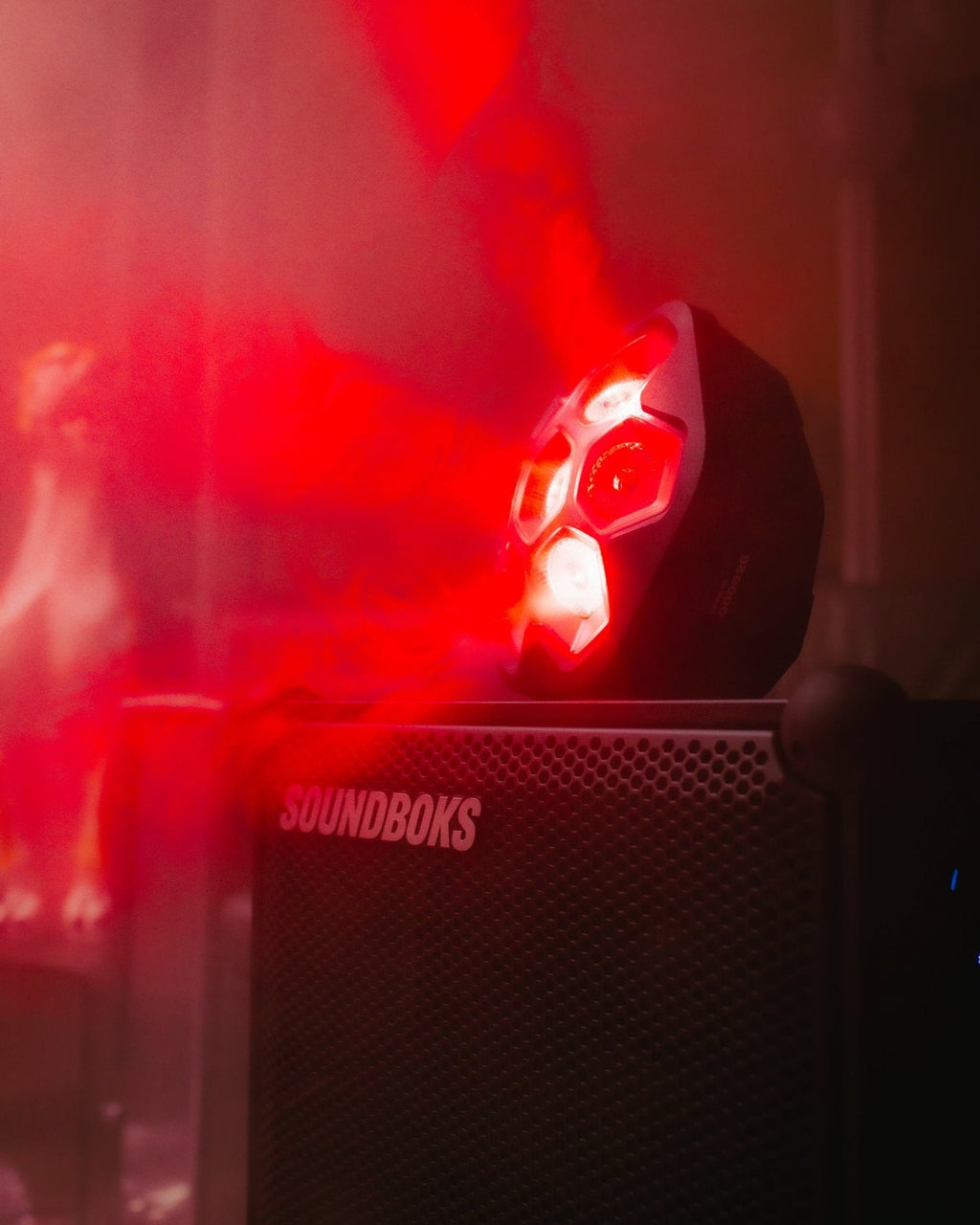 Soundboks-speaker met bovenop een rood oplichtende Lightboks in een donkere setting