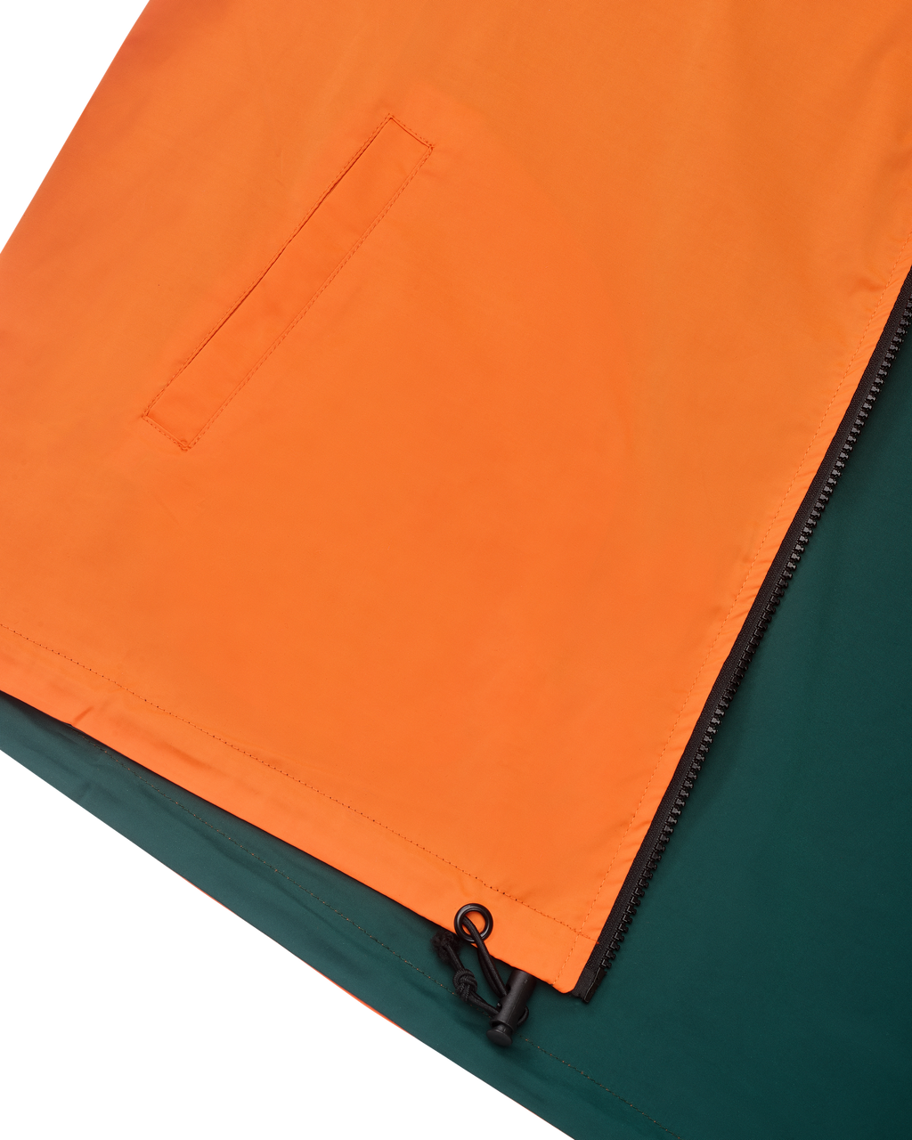 Close-up van een oranje en groene jas met een rits
