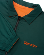 Close-up van de omkeerbare Jägermeister-jas met een rits waarbij de groene kant zichtbaar is