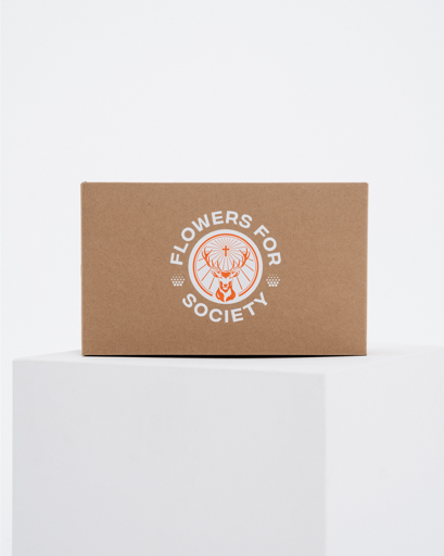 Een bruine kraftpapieren doos met een wit gedrukt Jägermeister-logo met daarop 'FLOWERS FOR SOCIETY'