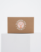 Een bruine kraftpapieren doos met een wit gedrukt Jägermeister-logo met daarop 'FLOWERS FOR SOCIETY'