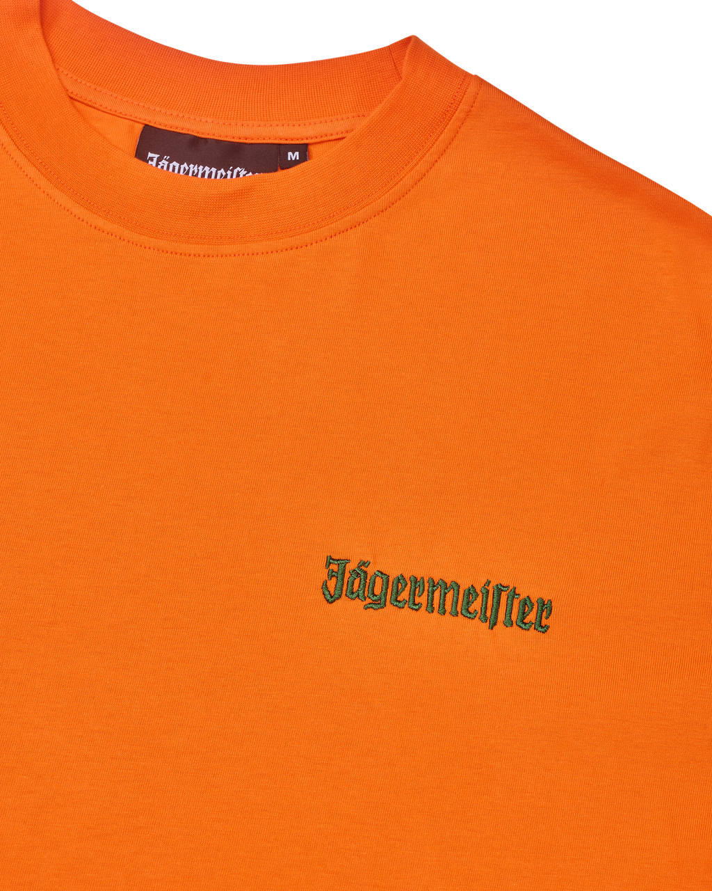 Oranje T-shirt met groen Jägermeister-logo op de borst.