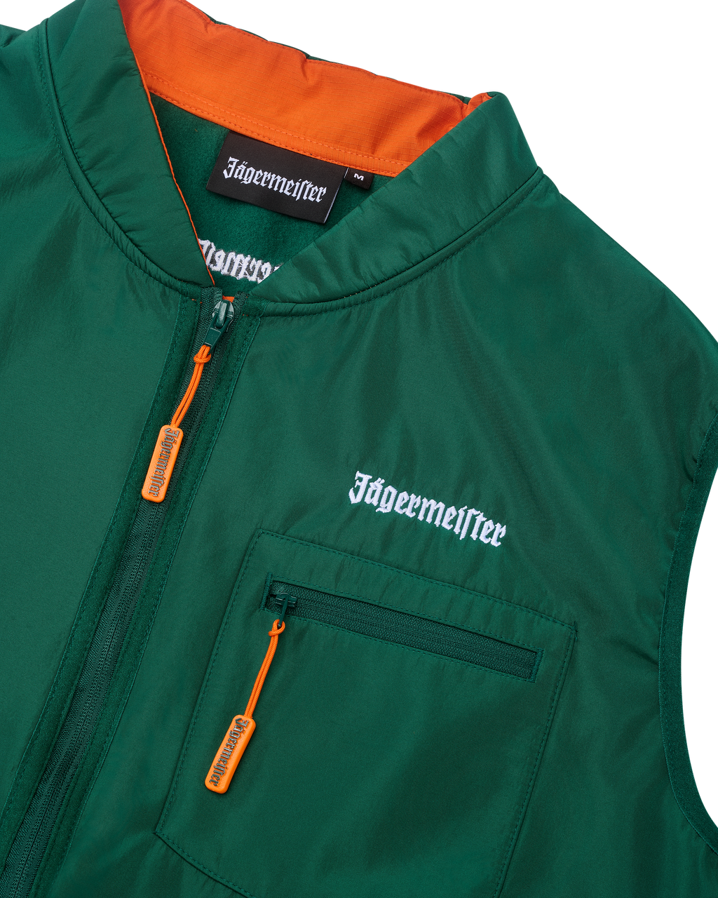 Groene vest met oranje binnenkant en witte Jägermeister-branding.