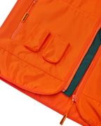 Close-up van een oranje Jägermeister-vest met twee voorzakken voor Jägermeister Minis.