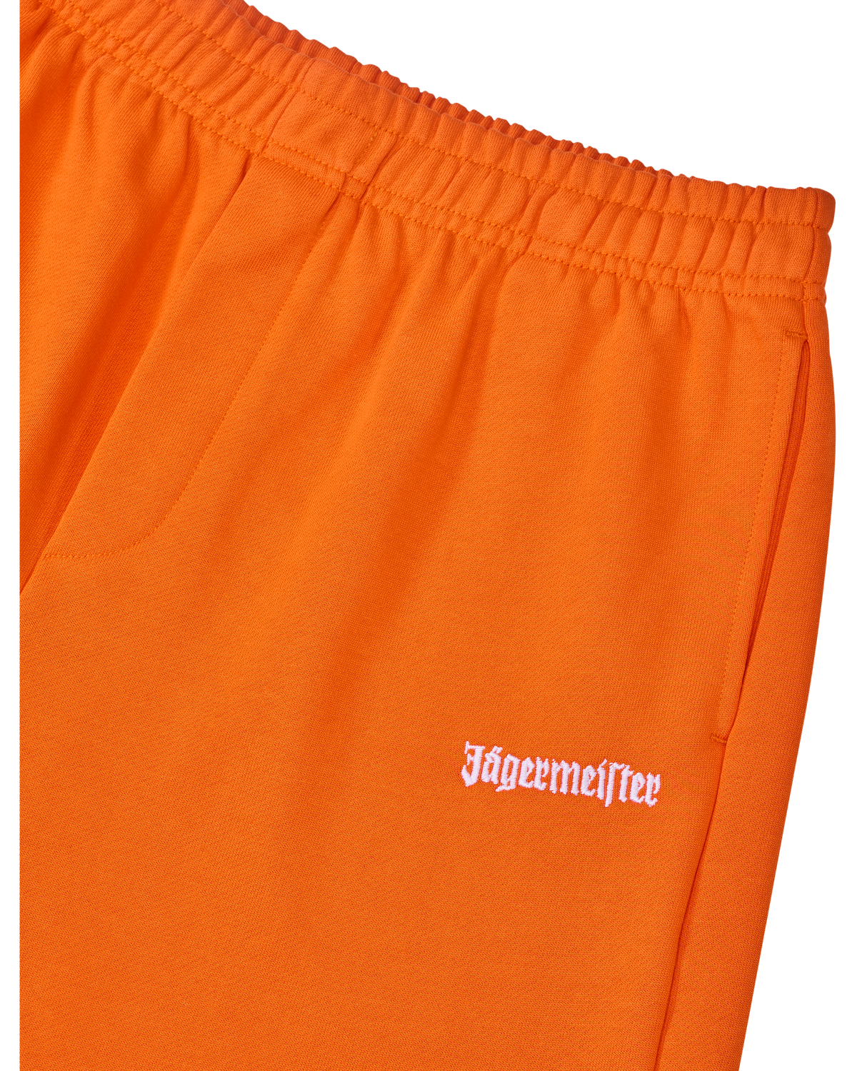 Oranje trainingsbroek met wit Jägermeister-logo op de zijkant.