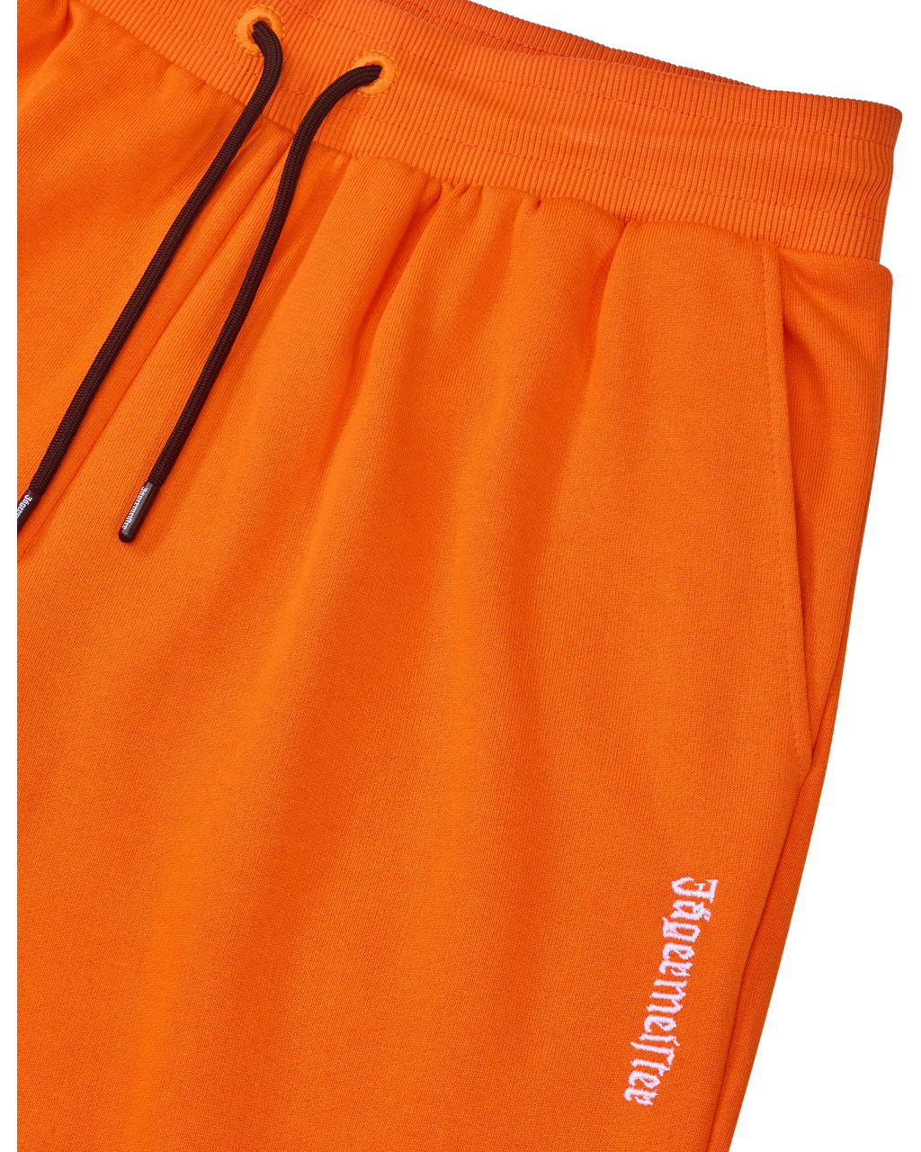 Oranje Jägermeister-sweatpants met een zwart trekkoord en een wit logo van het merk.