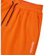 Oranje Jägermeister-sweatpants met een zwart trekkoord en een wit logo van het merk.