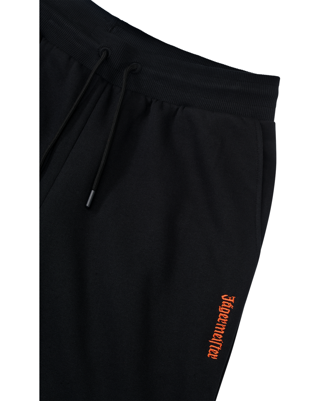 Zwarte trainingsbroek met oranje Jägermeister-logo op de zijkant.