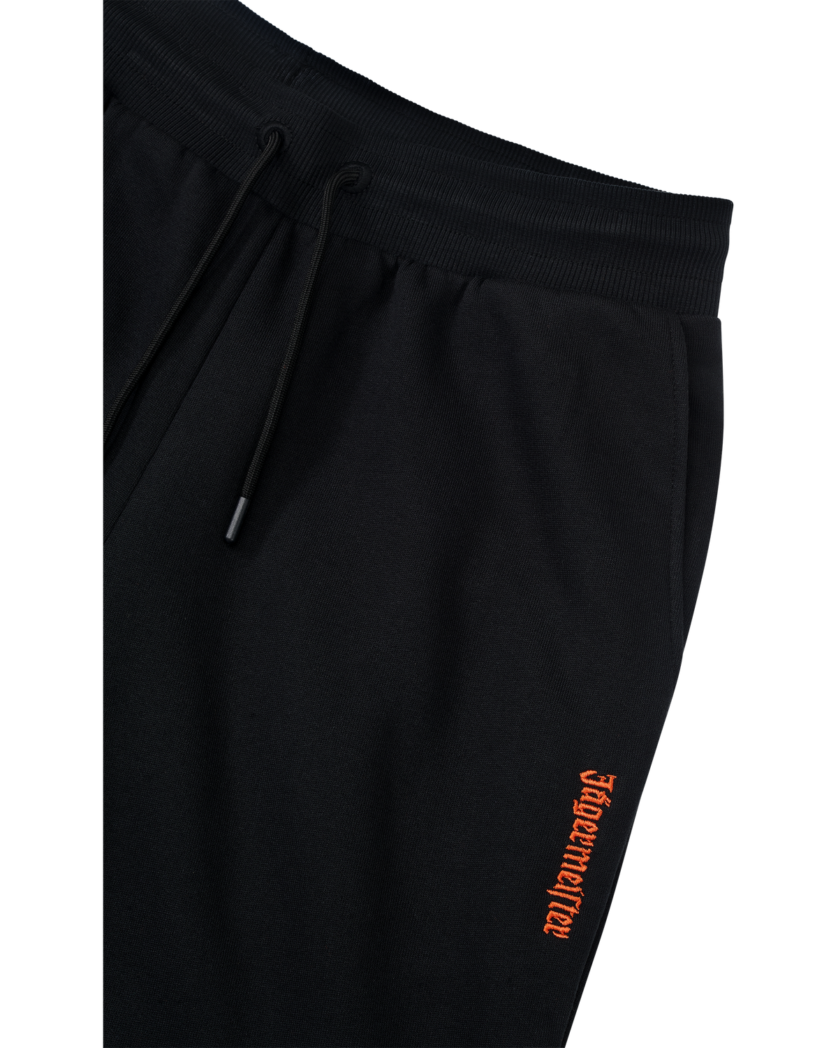 Zwarte trainingsbroek met oranje Jägermeister-logo op de zijkant.